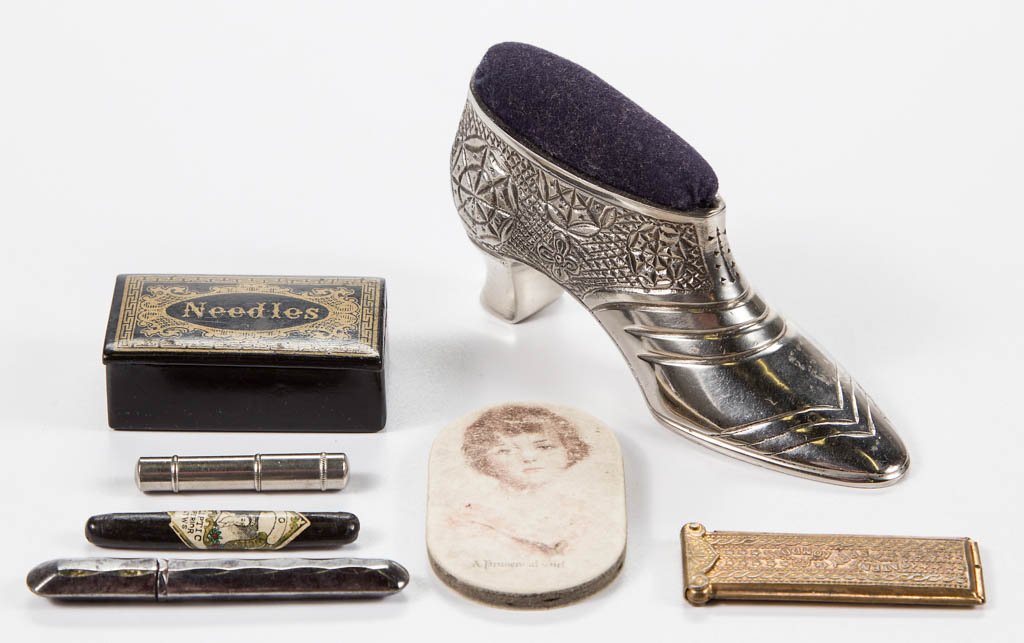 ASSORTED METAL AND OTHER SEWING NEEDLE CASES AND PIN: ASSORTED METAL AND OTHER SEWING NEEDLE CASES AND PIN CUSHIONS, LOT OF SEVEN, comprising five needle cases including a brass Perry & Co example, a black lacquered and gilt rectangular-form example, and