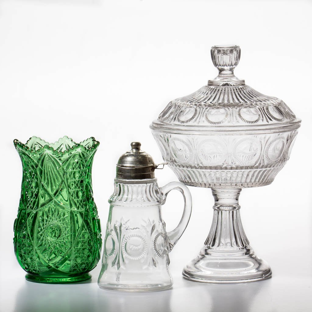 FOSTORIA'S ROBIN HOOD TABLE ARTICLES, LOT OF TWO: FOSTORIA'S ROBIN HOOD TABLE ARTICLES, LOT OF TWO, colorless, comprising a syrup pitcher, and a covered compote. Together with a green Fostoria Brazilian vase, with remnants of gilt decoration to rim. 