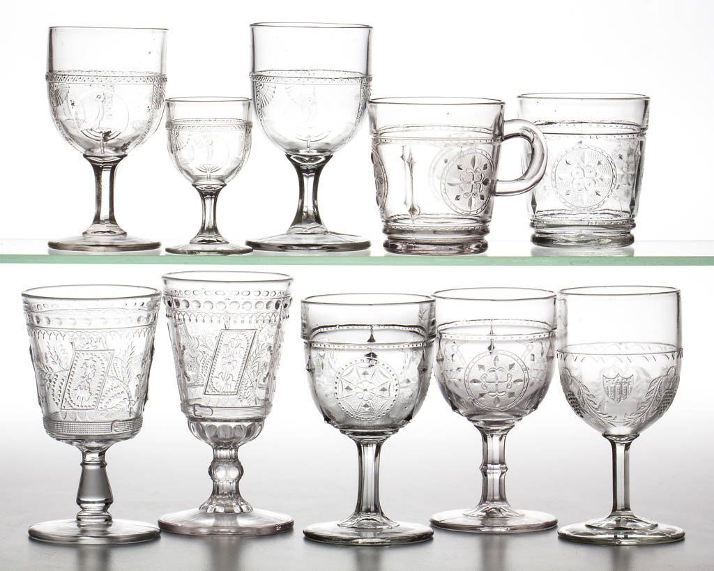 ASSORTED EAPG DRINKING ARTICLES, LOT OF TEN: ASSORTED EAPG DRINKING ARTICLES, LOT OF TEN, colorless, comprising two Good Luck goblets, two Parrot and Fans goblets, a Parrot and Fan wine, a Grape and Festoon goblet, two Columbian Exposition goble