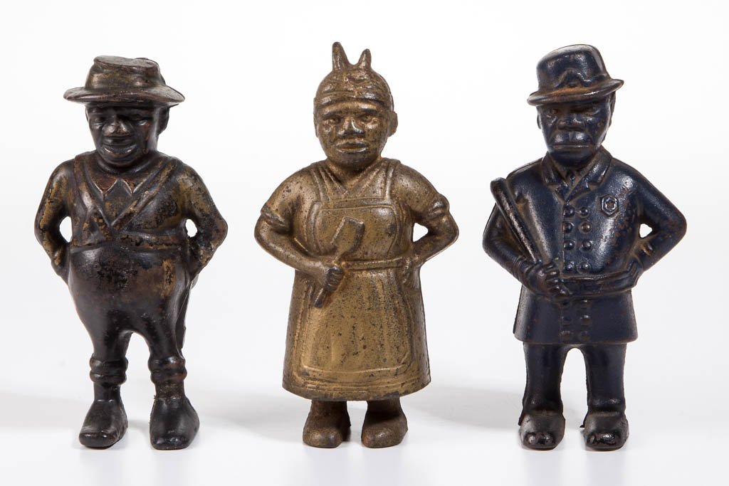 ASSORTED FIGURAL BLACK AMERICANA CAST-IRON PENNY BANKS,: ASSORTED FIGURAL BLACK AMERICANA CAST-IRON PENNY BANKS, LOT OF THREE, including a Mulligan, a Mammy, and a Sharecropper. Each in original paint. A. C. Williams Co., Ravenna, OH and others. First quart