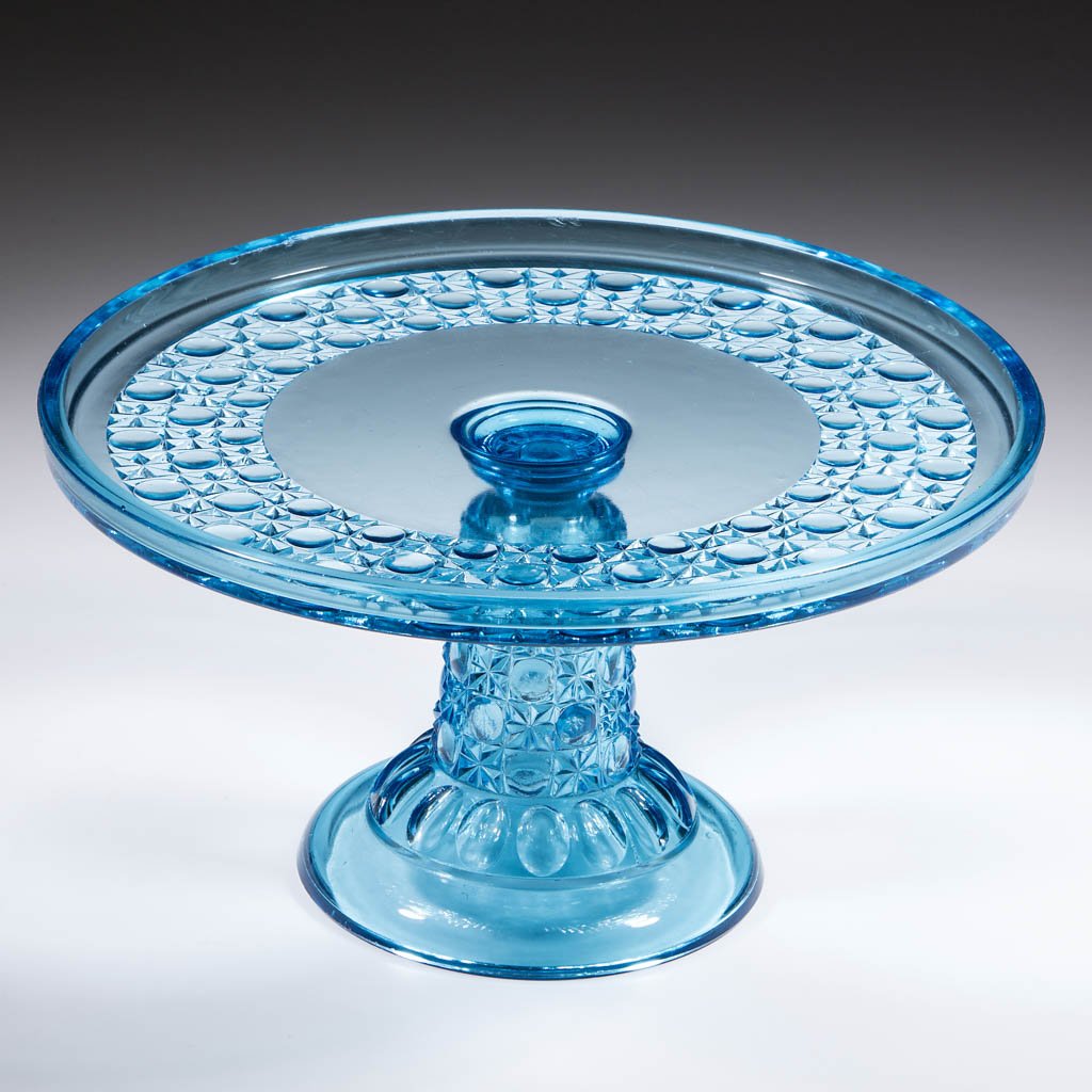 CURRIER AND IVES / CO-OP NO. 130 (OMN) SALVER / CAKE: CURRIER AND IVES / CO-OP NO. 130 (OMN) SALVER / CAKE STAND, blue. Co-Operative Flint Glass Co., Beaver Falls, PA. Circa 1887. 5 5/8" H, 10 3/8" D rim. Undamaged with moderate surface wear. Provenance: