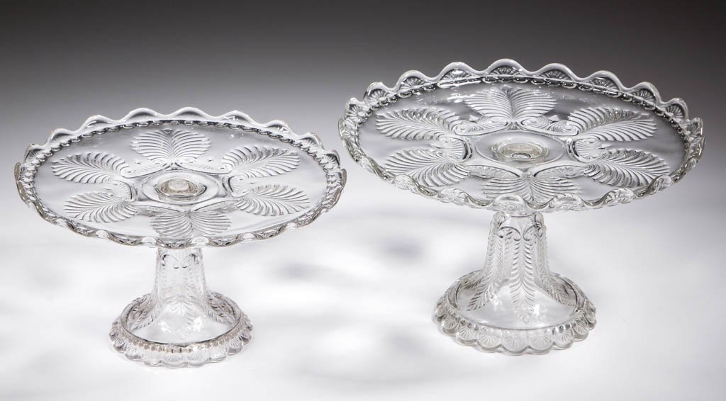 MISSOURI / PALM AND SCROLL SALVERS / CAKE STANDS, LOT: MISSOURI / PALM AND SCROLL SALVERS / CAKE STANDS, LOT OF TWO, colorless, two sizes, each with upturned scalloped rim, on high standard. U. S. Glass Co. Circa 1899. 5" and 6" H, 8 3/4" and 9 3/4" D rim