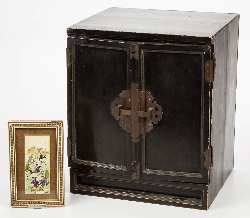 CHINESE LACQUER CABINET: CHINESE LACQUER CABINET, two hinged doors, ebonized surface, original hardware. Together with a painted bone panel depicting a hunt scene, possibly Indo-Persian, housed under glass in an inlaid frame.