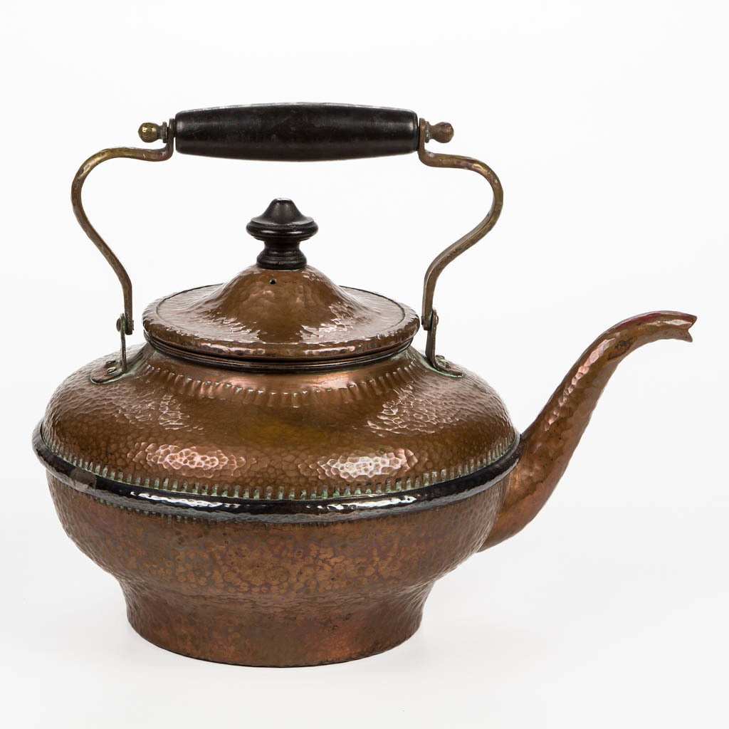JOSEPH HEINRICHS MIXED-METAL ARTS AND CRAFTS HOT WATER: JOSEPH HEINRICHS MIXED-METAL ARTS AND CRAFTS HOT WATER / TEA KETTLE, spot-hammered surface throughout, turned wooden handle grip and cover finial, each ebonized, brass handle frame, applied silver med