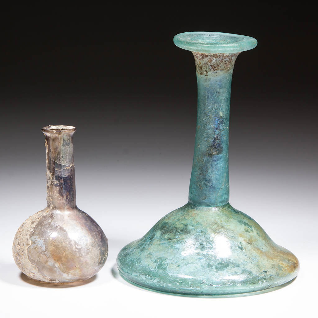 ASSORTED ANCIENT GLASS BOTTLES, LOT OF TWO: ASSORTED ANCIENT GLASS BOTTLES, LOT OF TWO, colorless and aquamarine, colorless with a bulbous base and elongated neck, aquamarine with a kick-up base and elongated neck with a folded over rim. Maker 