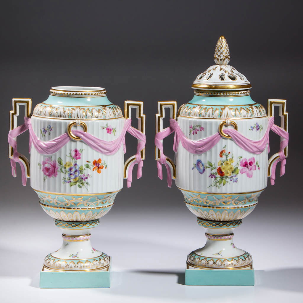 GERMAN KPM PORCELAIN URNS, LOT OF TWO: GERMAN KPM PORCELAIN URNS, LOT OF TWO, both bolted, one with a pierced cover and one without a cover, both having geometric molded handles on opposite sides, wrapped in a pink ribbon, and polychrome f