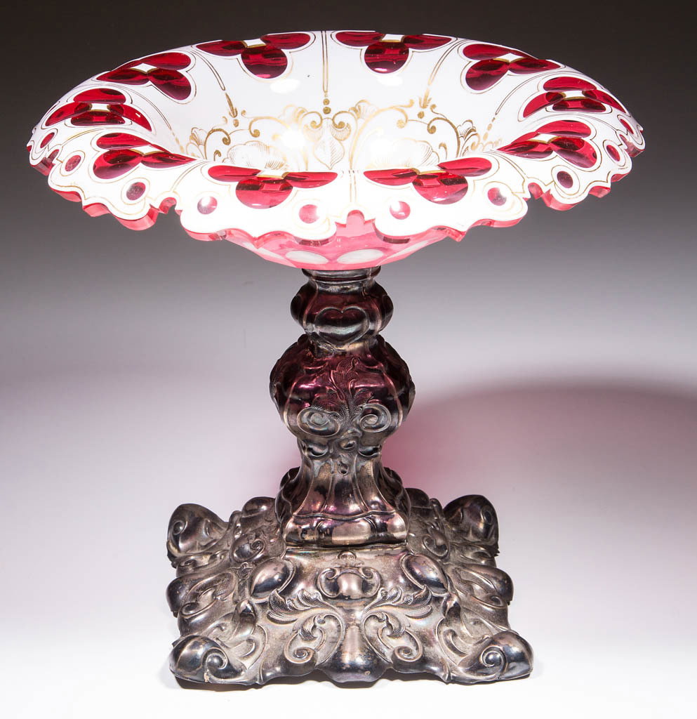 EUROPEAN QUATREFOIL CUT OVERLAY COMPOTE: EUROPEAN QUATREFOIL CUT OVERLAY COMPOTE, opaque white to cranberry lead glass with gilt decoration, overhanging factory-polished rim, quatrefoils encompassing the interior of the bowl with ornate gilt