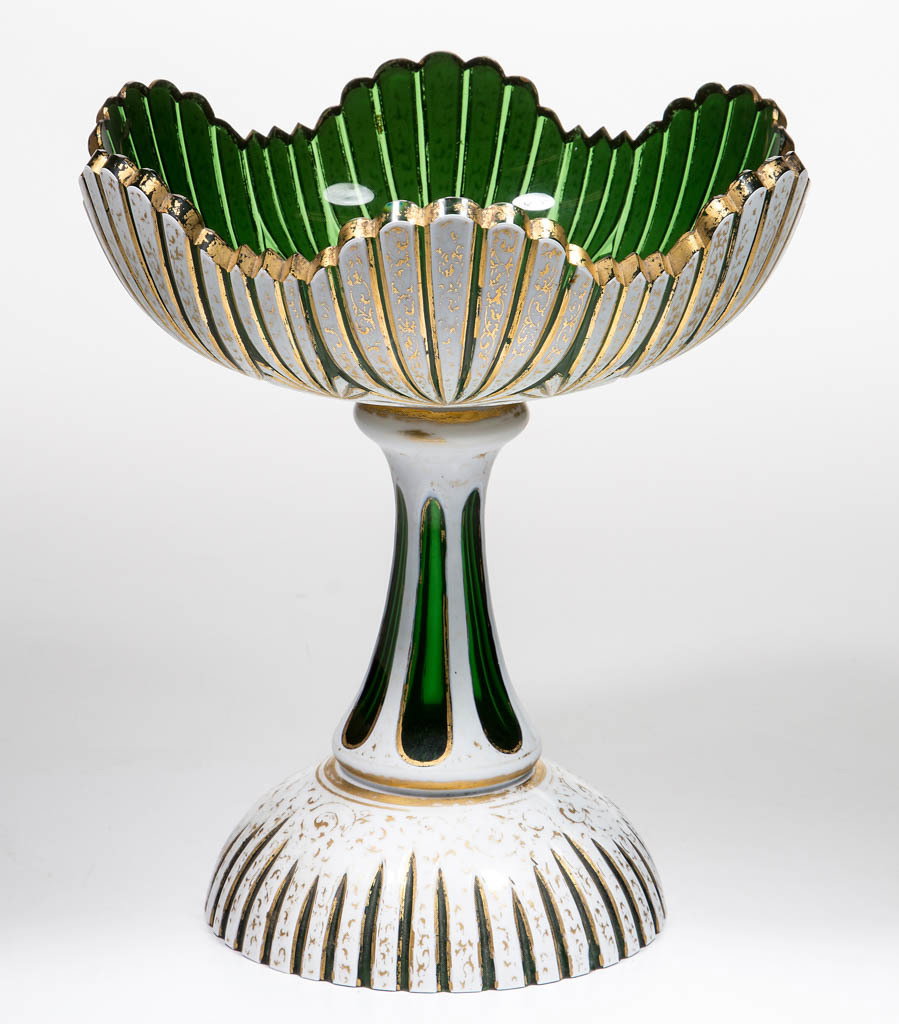 BOHEMIAN CUT OVERLAY OPEN COMPOTE: BOHEMIAN CUT OVERLAY OPEN COMPOTE, opaque white to emerald green lead glass with ornate gilt decoration, seashell motif bowl and domed foot, panel-cut standard, factory-polished rim and base. Third qu