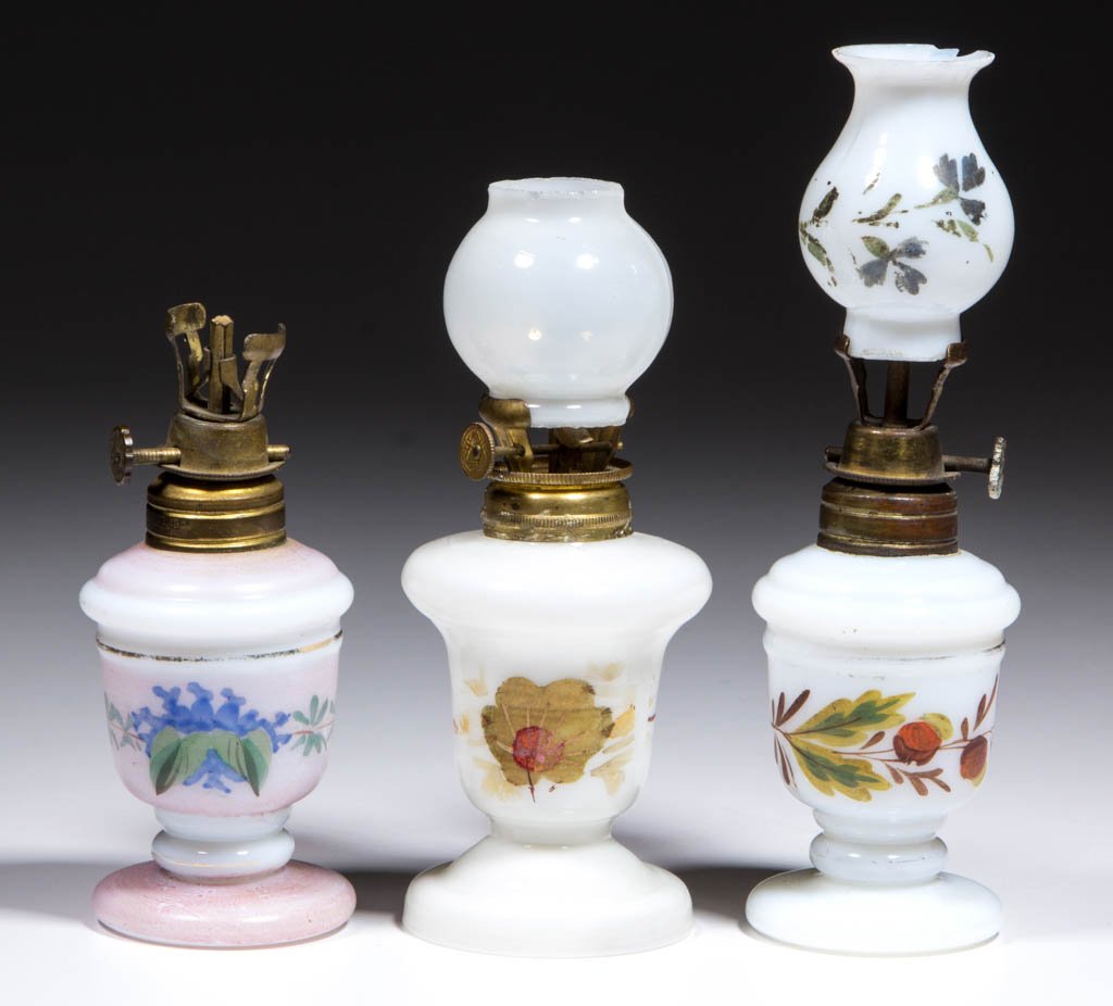 ASSORTED DECORATED OPAQUE GLASS MINIATURE LAMPS, LOT OF: ASSORTED DECORATED OPAQUE GLASS MINIATURE LAMPS, LOT OF THREE, opaque white with various polychrome floral decoration, one example with light opalescence, urn-forms with shoulder ring and pedestal foo