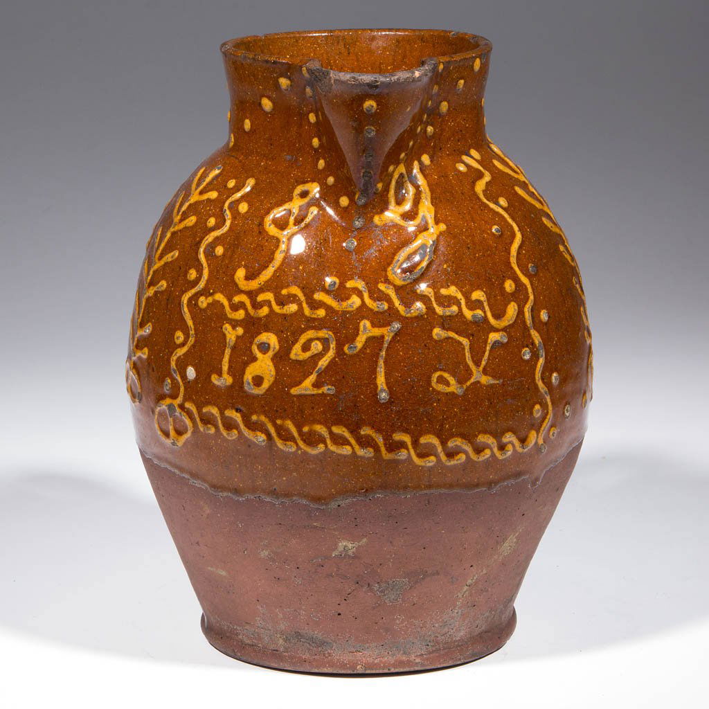 ENGLISH SLIP- DECORATED EARTHENWARE / REDWARE PITCHER: ENGLISH SLIP- DECORATED EARTHENWARE / REDWARE PITCHER, lead-glazed upper body, approximately one-gallon capacity, ovoid form with short neck, strap handle, and heavy beaded foot. Yellow-slipped "J G /