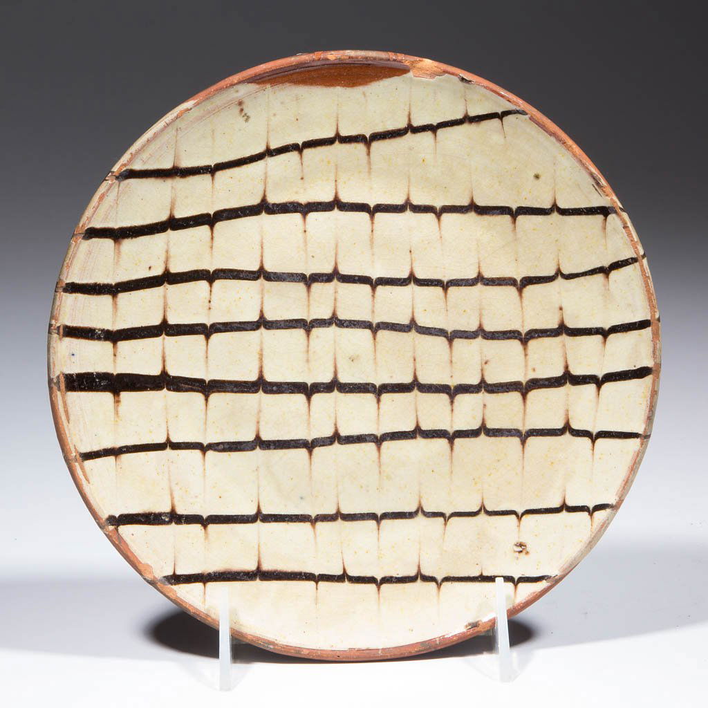 ENGLISH SLIP-DECORATED EARTHENWARE / REDWARE PLATE /: ENGLISH SLIP-DECORATED EARTHENWARE / REDWARE PLATE / STAND, lead- and manganese-glazed, thick circular form with lightly beaded rim and combed yellow-slipped decoration. Late 18th/early 19th century.