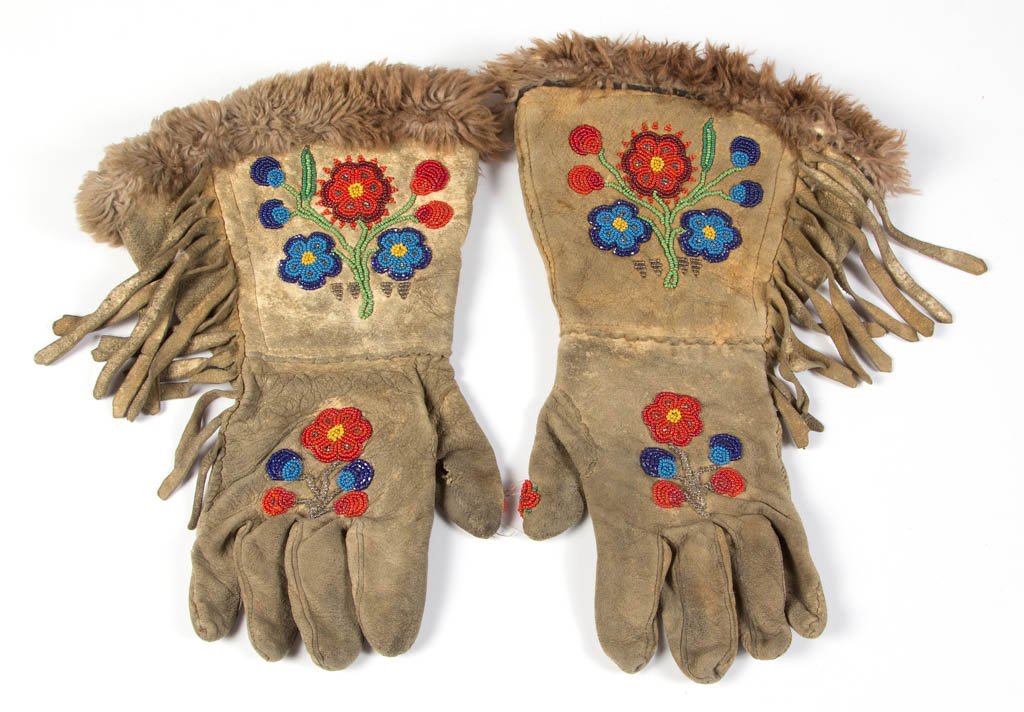 PLAINS NATIVE AMERICAN BEADED HIDE PAIR OF GAUNTLETS /: PLAINS NATIVE AMERICAN BEADED HIDE PAIR OF GAUNTLETS / GLOVES, each with polychrome floral decoration, side fringe, fur openings, and velvet interior lining. Late 19th/first half 20th century. 12 1/2"