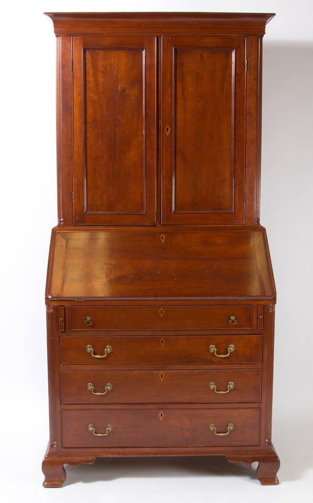 AMERICAN CHIPPENDALE CHERRY DESK AND BOOKCASE: AMERICAN CHIPPENDALE CHERRY DESK AND BOOKCASE, two-piece construction, the upper section having applied cove-molded cornice over two hinged fielded-panel doors concealing two fixed shelves and bank of