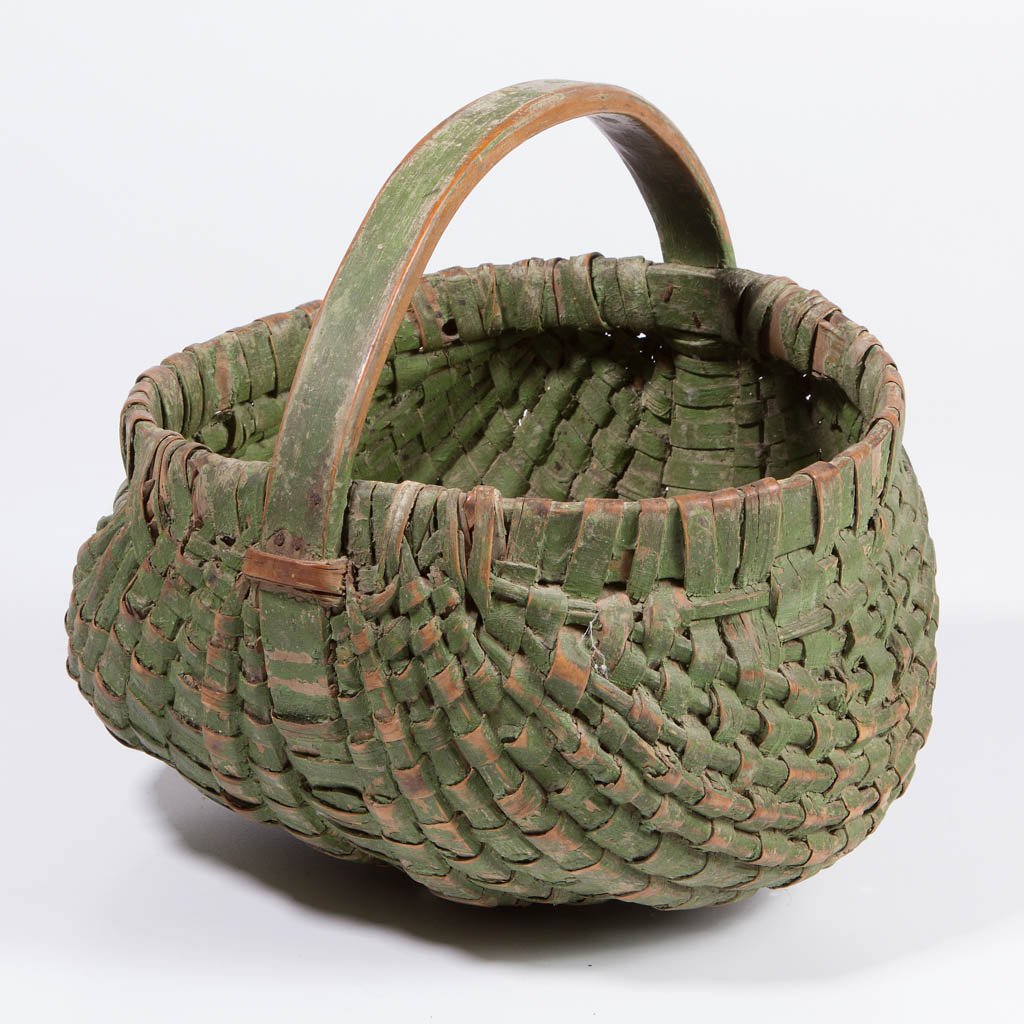 AMERICAN PAINTED RIB-TYPE WOVEN-SPLINT BASKET: AMERICAN PAINTED RIB-TYPE WOVEN-SPLINT BASKET, heavy kidney-form with wrapped rim, arched handle, and horizontal handle supports. Original dry green-painted surface. Late 19th/early 20th century. 11 1