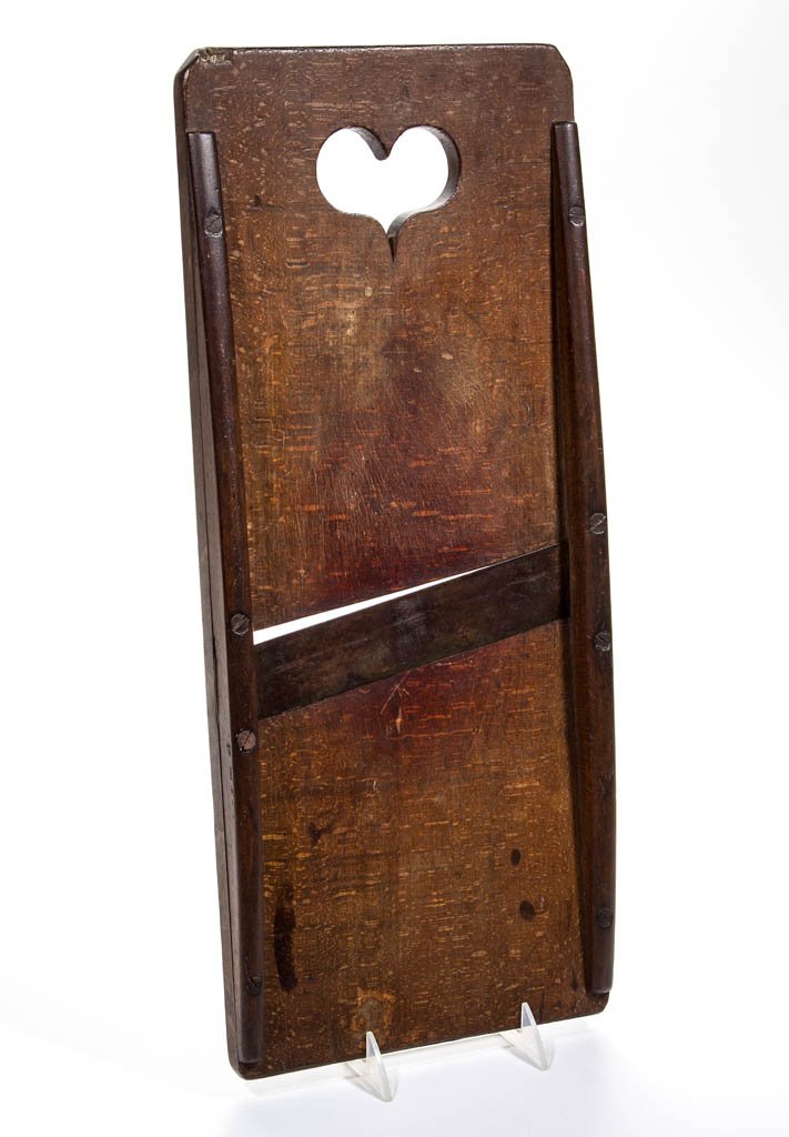 PENNSYLVANIA FIGURED MAPLE SLAW BOARD: PENNSYLVANIA FIGURED MAPLE SLAW BOARD, rectangular form with large cut-out heart at top and original blade. Excellent old, warm surface. First half 19th century. 21" x 8 3/4". Excellent as-found condi