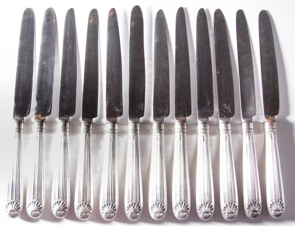 ENGLISH STERLING SILVER DINNER KNIVES, SET OF 12: ENGLISH STERLING SILVER DINNER KNIVES, SET OF 12, each hollow handle with chased crest decoration depicting a stork or heron, George III duty mark, 1805 date mark, and maker's mark for Moses Brent. Ci