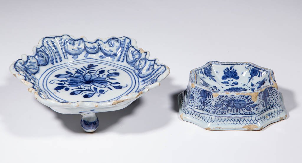 DUTCH DELFT TIN-GLAZED EARTHENWARE ARTICLES, LOT OF TWO: DUTCH DELFT TIN-GLAZED EARTHENWARE ARTICLES, LOT OF TWO, comprising one sweetmeat tray on three raised bun feet, having a relief-decorated edge and central floral spray, linear designs on underside; a