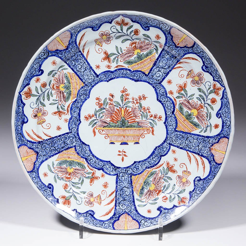 DUTCH DELFT TIN-GLAZED EARTHENWARE PLATE: DUTCH DELFT TIN-GLAZED EARTHENWARE PLATE, polychrome design with baskets of flowers painted within cartouches and geometric designs on rim and interior. "M.P." painted on reverse. Likely Pieter Paree,