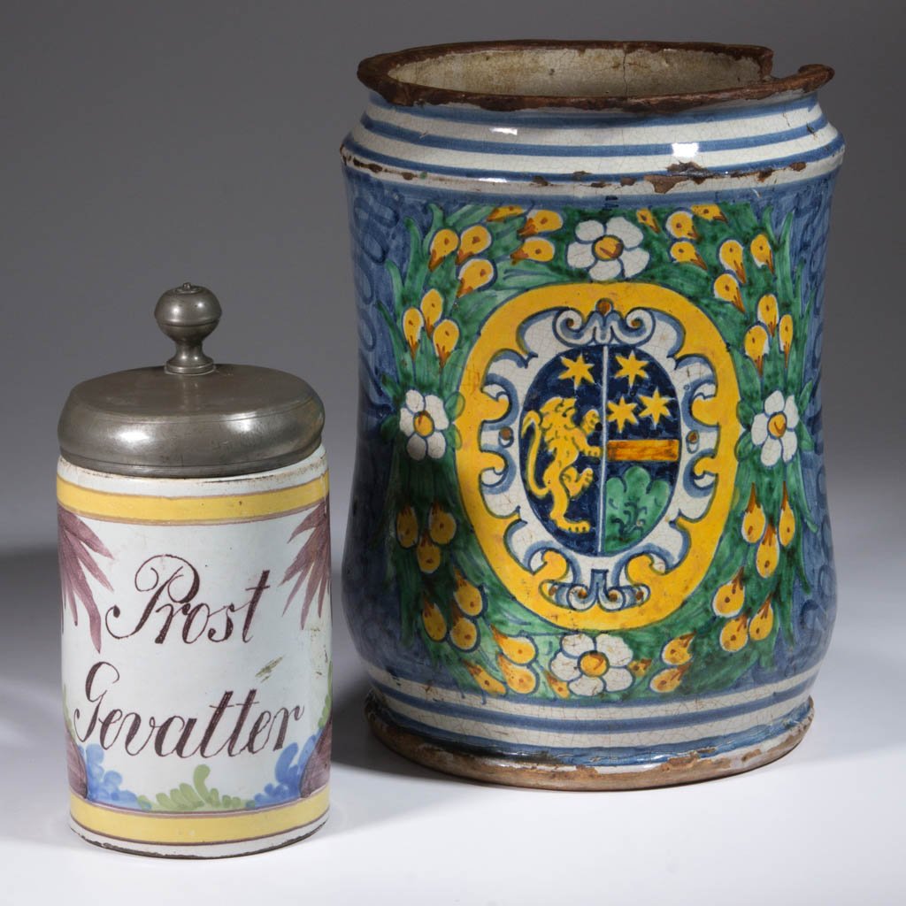 CONTINENTAL DELFT TIN-GLAZED EARTHENWARE ARTICLES, LOT: CONTINENTAL DELFT TIN-GLAZED EARTHENWARE ARTICLES, LOT OF TWO, comprising one large urn with flared base and foot having bright polychrome floral and heraldry crest; and one tankard having "Prost / Ge