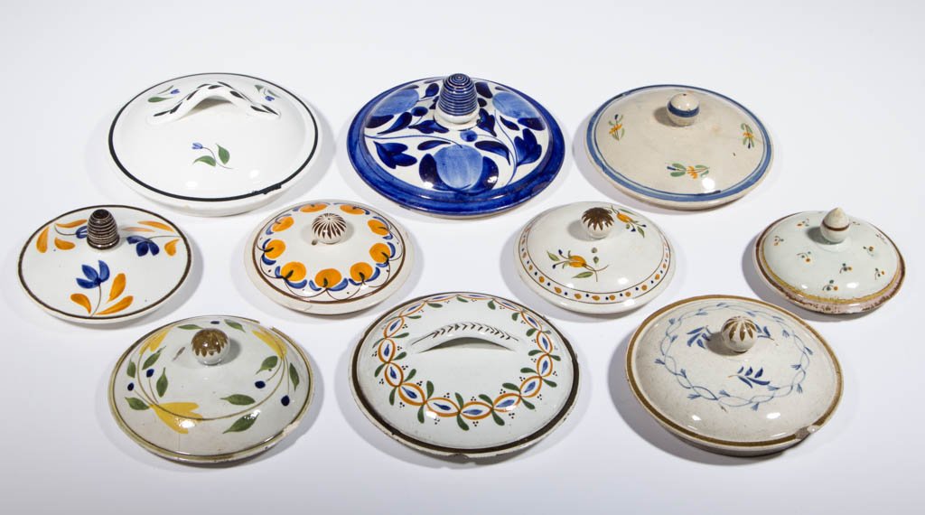 ENGLISH PEARLWARE CERAMIC COVERS, LOT OF TEN: ENGLISH PEARLWARE CERAMIC COVERS, LOT OF TEN, having a variety of polychrome hand-painted decorations and finials or strap handles. Unmarked. Staffordshire and other areas. Circa 1810. 3 1/4" to 5" D.