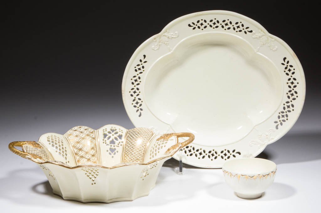 ASSORTED CREAMWARE ARTICLES, LOT OF THREE: ASSORTED CREAMWARE ARTICLES, LOT OF THREE, comprising one teabowl impressed "WEDGWOOD" with molded shell edge on side and gilding; one unmarked lobed and fluted basket with pierced panels and gilt pai
