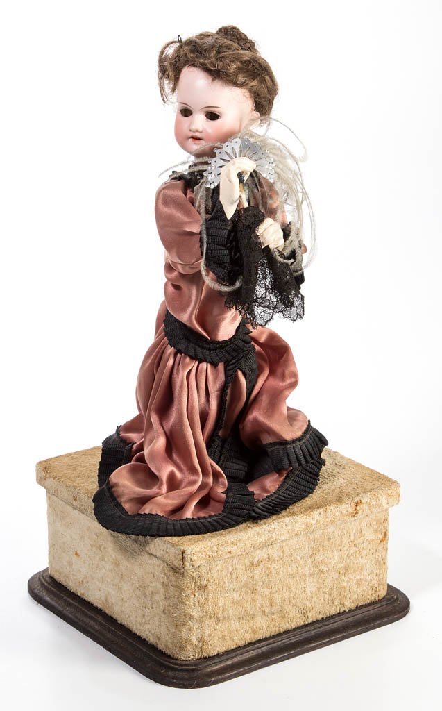 ARMAND MARSEILLE GERMAN BISQUE-HEAD AUTOMATON DOLL: ARMAND MARSEILLE GERMAN BISQUE-HEAD AUTOMATON DOLL, socket head inscribed "AM DEP / Made in Germany / 2/0", sleep eyes and open mouth with teeth, wooden limbs, movable on a velvet covered music box wi