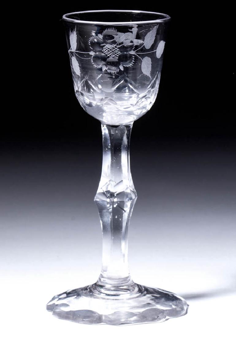 ENGLISH FREE-BLOWN, CUT, AND ENGRAVED FACET-STEM WINE: ENGLISH FREE-BLOWN, CUT, AND ENGRAVED FACET-STEM WINE GLASS, colorless lead glass, round funnel bowl cut and engraved with a rose, seven leaves, and bird in flight, cut basal scales, raised on a hexag