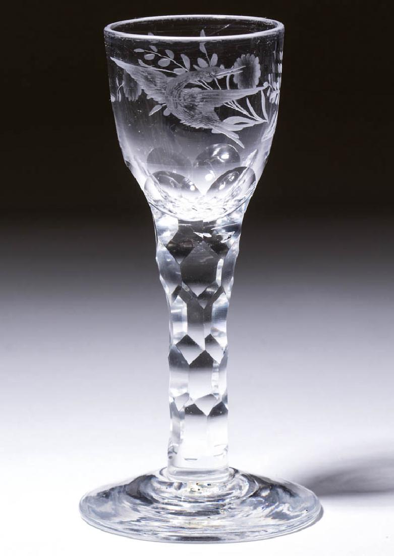 ENGLISH FREE-BLOWN AND ENGRAVED FACET-STEM WINE GLASS: ENGLISH FREE-BLOWN AND ENGRAVED FACET-STEM WINE GLASS, colorless lead glass, ogee bowl with double-bloom floral spray backed with a bird in flight on reverse, raised on a cut six-sided hexagonal-facet