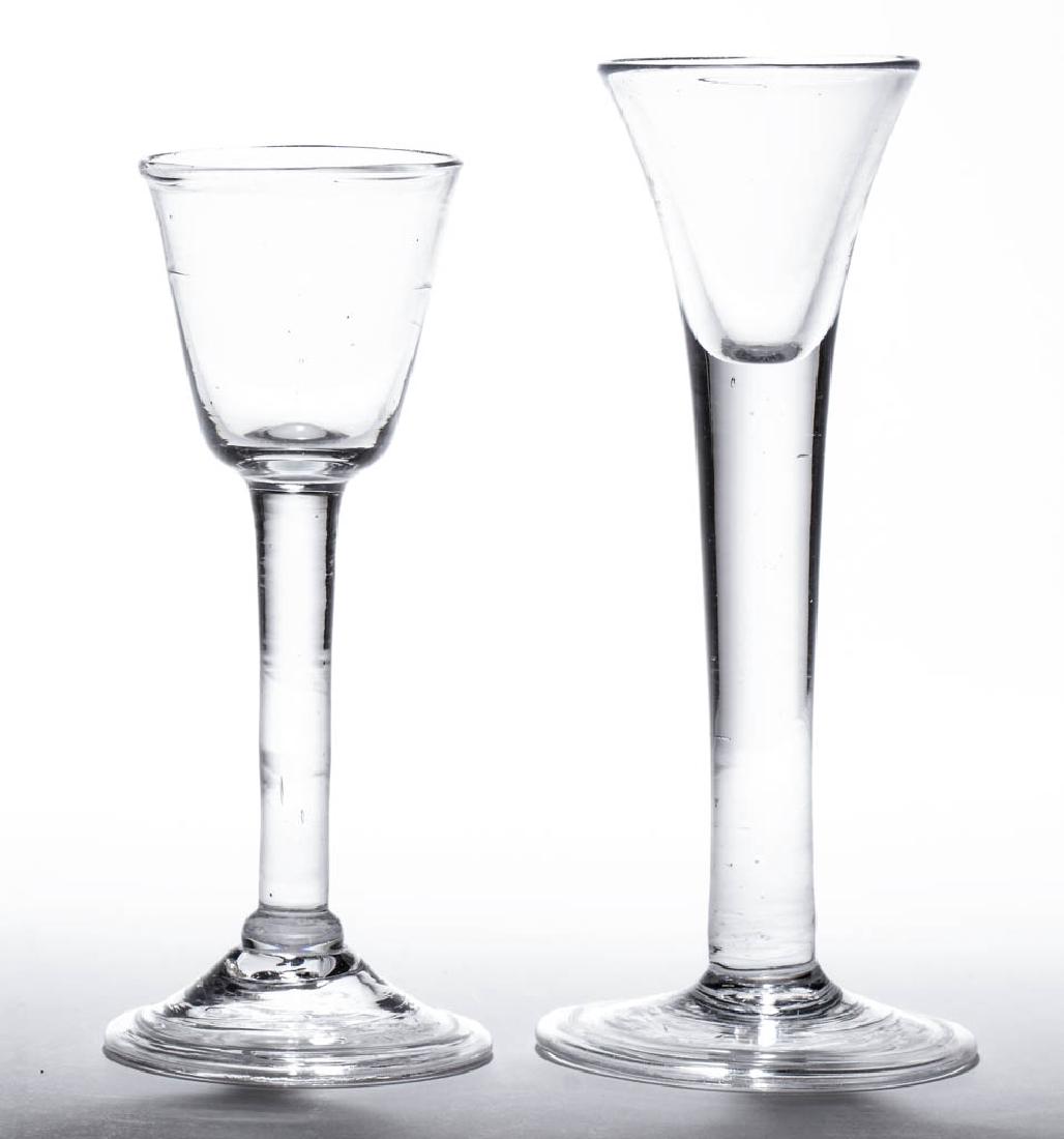 ENGLISH FREE-BLOWN DRINKING VESSELS, LOT OF TWO: ENGLISH FREE-BLOWN DRINKING VESSELS, LOT OF TWO, colorless lead glass, comprising a trumpet-bowl dram glass with heavy drawn stem, and a wine glass featuring a rounded funnel bowl raised on a plain st