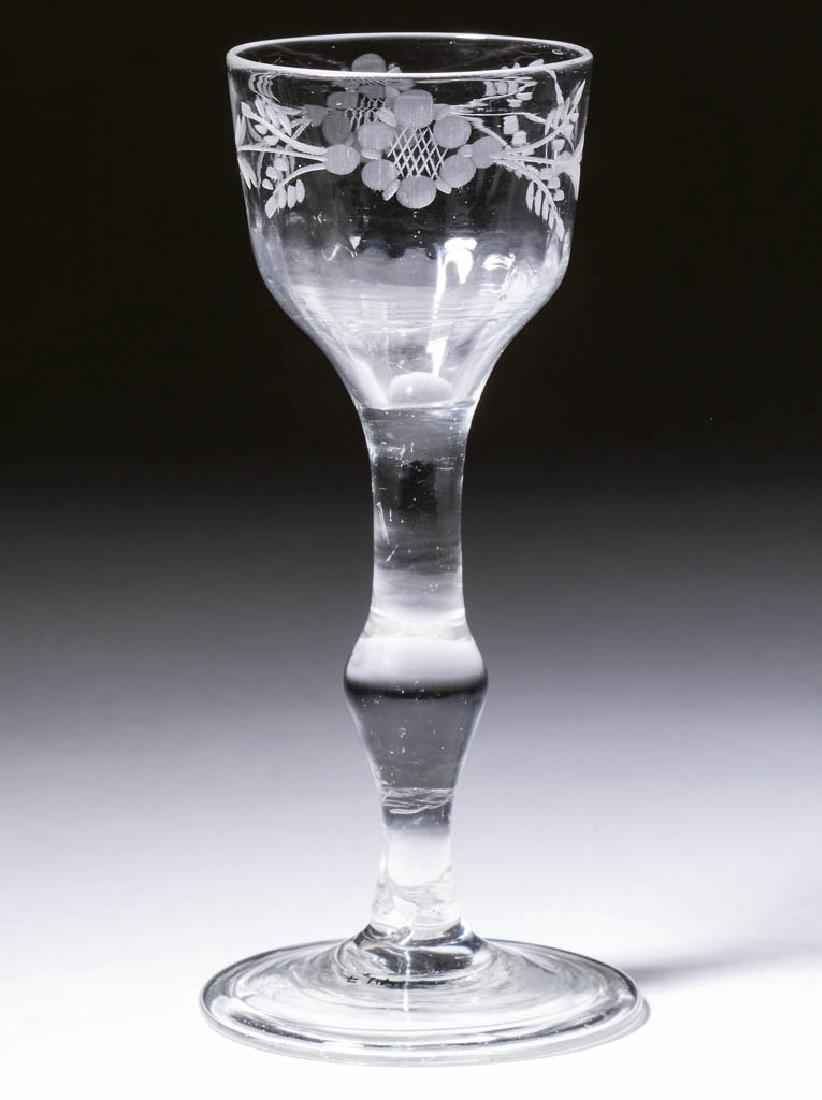 ENGLISH PATTERN-MOLDED AND ENGRAVED WINE GLASS: ENGLISH PATTERN-MOLDED AND ENGRAVED WINE GLASS, colorless lead glass, ogee bowl with basal flutes, engraved with a foliate band below rim, raised on a stem with swelled center knop, conical folded foo