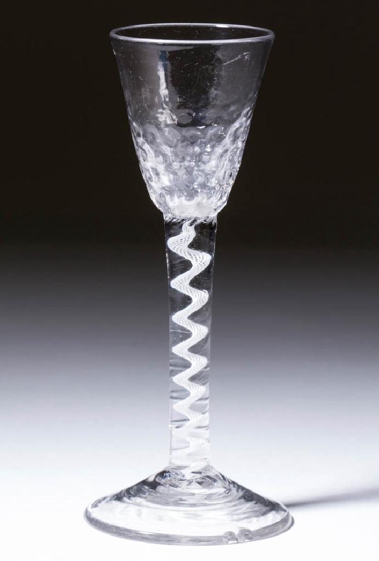 ENGLISH PATTERN-MOLDED OPAQUE-TWIST WINE GLASS: ENGLISH PATTERN-MOLDED OPAQUE-TWIST WINE GLASS, colorless lead glass, round pointed funnel bowl with heavily molded base, raised on a stem containing a spiral gauze, conical foot with rough pontil mar