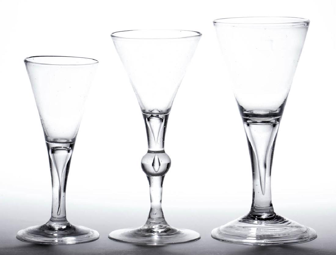 CONTINENTAL FREE-BLOWN WINE GLASSES, LOT OF THREE: CONTINENTAL FREE-BLOWN WINE GLASSES, LOT OF THREE, colorless non-lead glass, each funnel bowl raised on a drawn teared stem, one with center knop, each on a conical foot with rough pontil mark, two wi