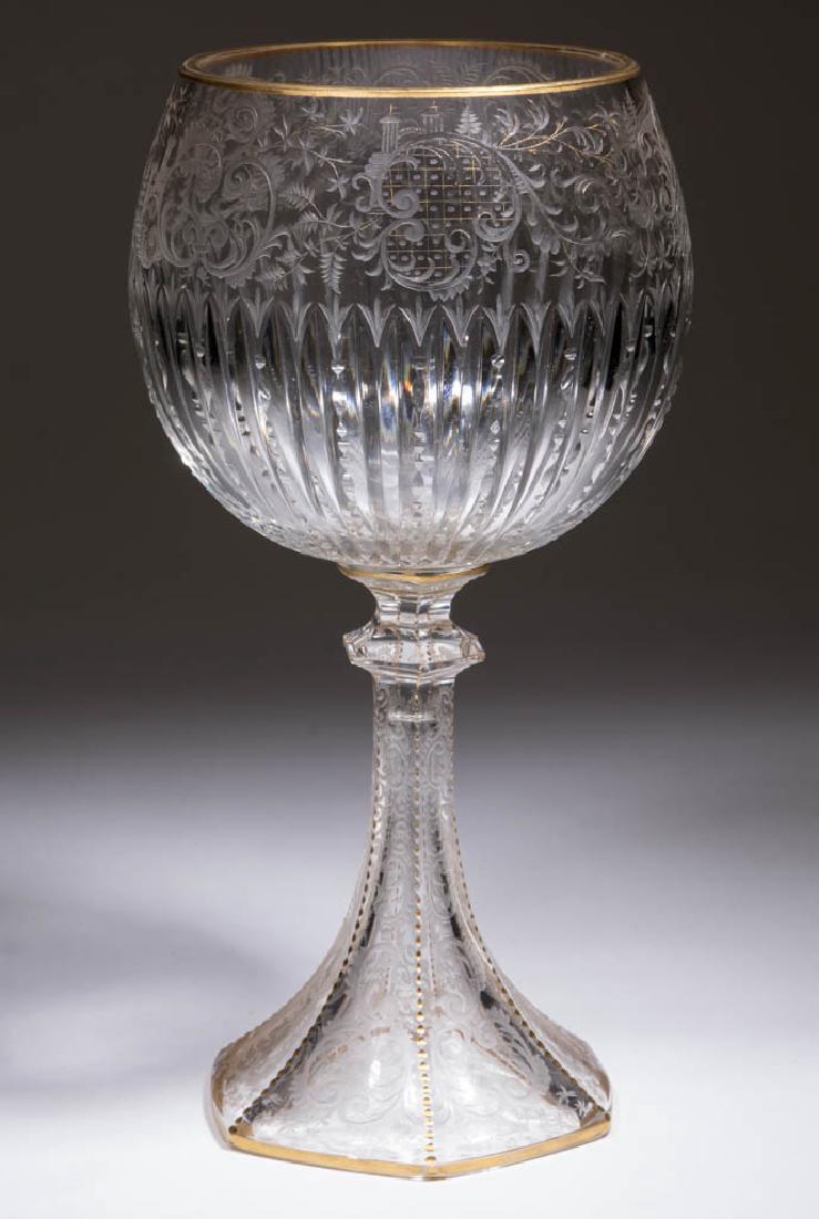 BOHEMIAN CUT AND ENGRAVED LARGE CHALICE: BOHEMIAN CUT AND ENGRAVED LARGE CHALICE, colorless with gilt highlights, globular bowl with an ornate band of foliage, scrollwork, and structures above notched and plain prisms, raised on a hexagonal 