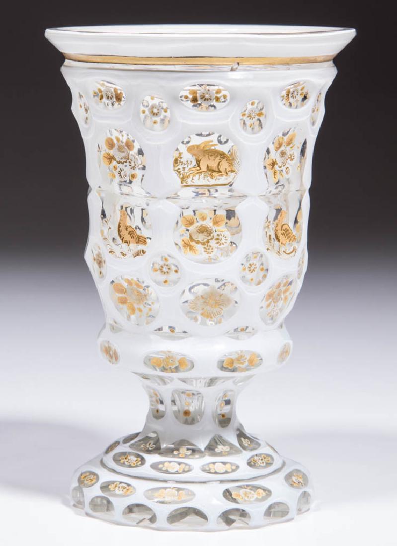 BOHEMIAN CUT OVERLAY AND DECORATED FOOTED BEAKER /: BOHEMIAN CUT OVERLAY AND DECORATED FOOTED BEAKER / TUMBLER, white to colorless, bowl with grooved punty band surrounded by smaller ovals and punties, each cutting enamel- and gilt-decorated with depic