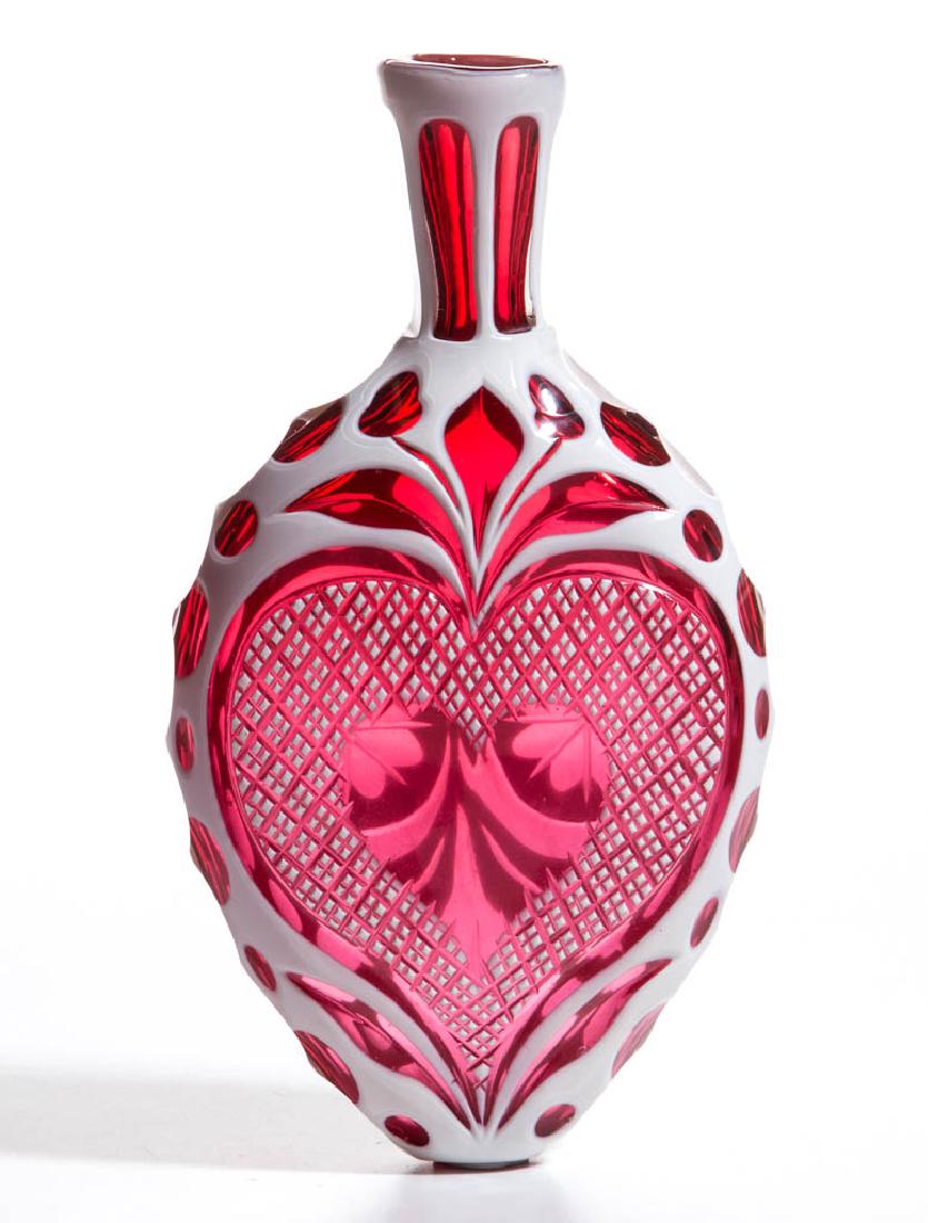CUT OVERLAY FLORAL AND PUNTY FLASK: CUT OVERLAY FLORAL AND PUNTY FLASK, opaque white to ruby, panelled neck, sides with quatrefoil cuts, one face with eight-petal flowers with swags and acorn decoration, reverse with a multi-tier heart 