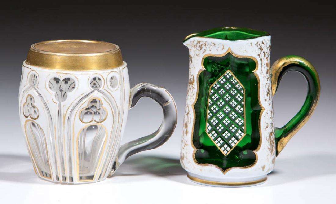 EUROPEAN CUT OVERLAY ARTICLES, LOT OF TWO: EUROPEAN CUT OVERLAY ARTICLES, LOT OF TWO, comprising a white to green diminutive creamer with cross-hatched panels and ornate gilt decoration, and a white to colorless mug/punch cup with a gothic pat