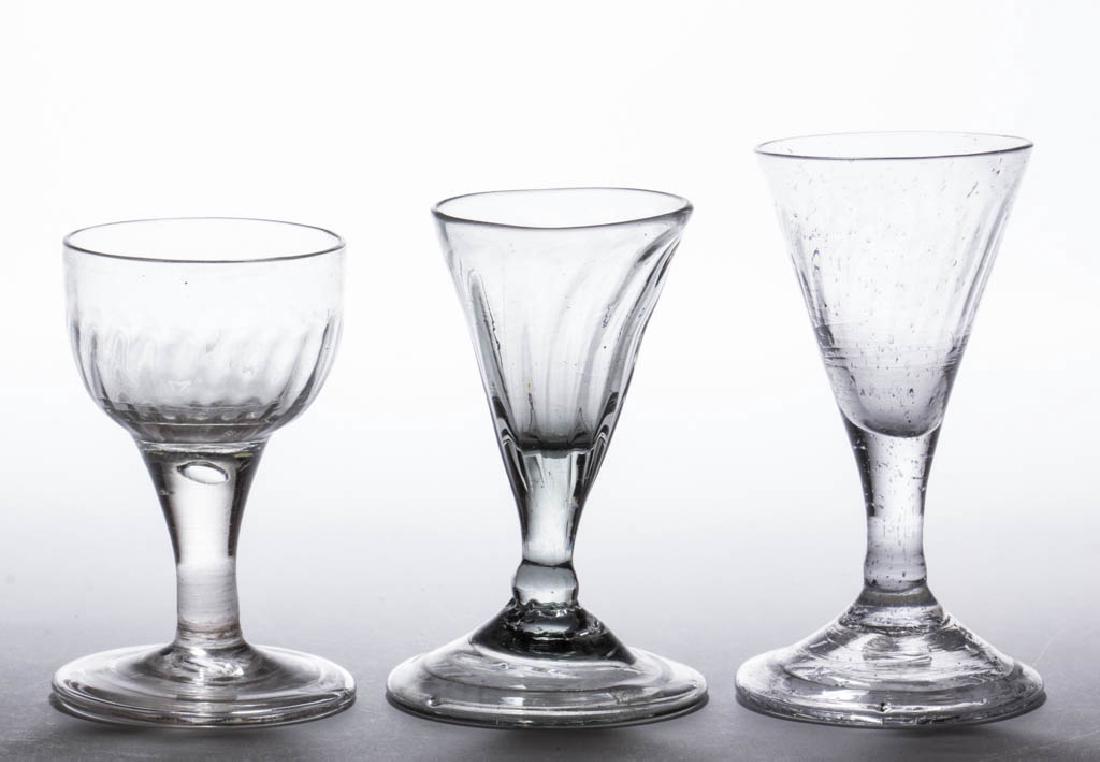 ASSORTED PATTERN-MOLDED WINE GLASSES, LOT OF THREE: ASSORTED PATTERN-MOLDED WINE GLASSES, LOT OF THREE, colorless, comprising a smoke-tinted non-lead example with 12 ribs on the conical bowl, a lead example with 26 ribs on conical bowl, and a lead exam