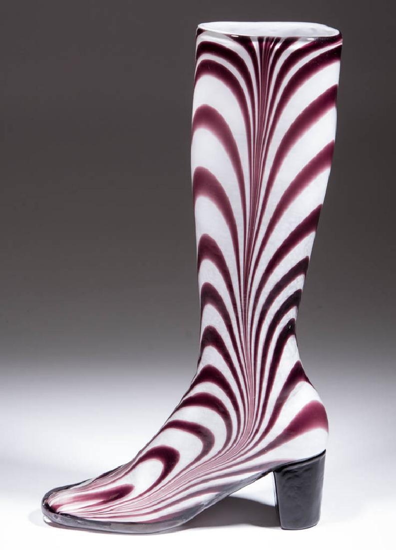 MARBRIE-DECORATED WHIMSY BOOT: MARBRIE-DECORATED WHIMSY BOOT, opal-cased colorless with amethyst decoration, applied heel, polished base and pontil mark. Maker unverified. 20th century. 15 7/8" H, 9" LOA base. Undamaged. Provenance