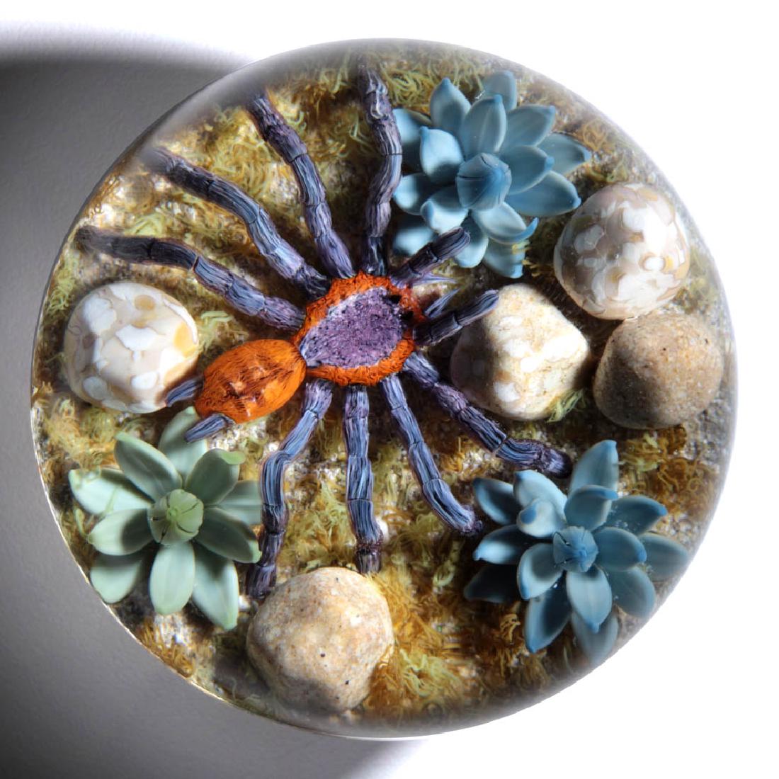GORDON SMITH STUDIO ART GLASS LAMPWORK PAPERWEIGHT: GORDON SMITH STUDIO ART GLASS LAMPWORK PAPERWEIGHT, depicting a purple and orange tarantula among pebbles and agave plants, all on a grassy and sandy ground, signature "GS" cane to side, and numbered