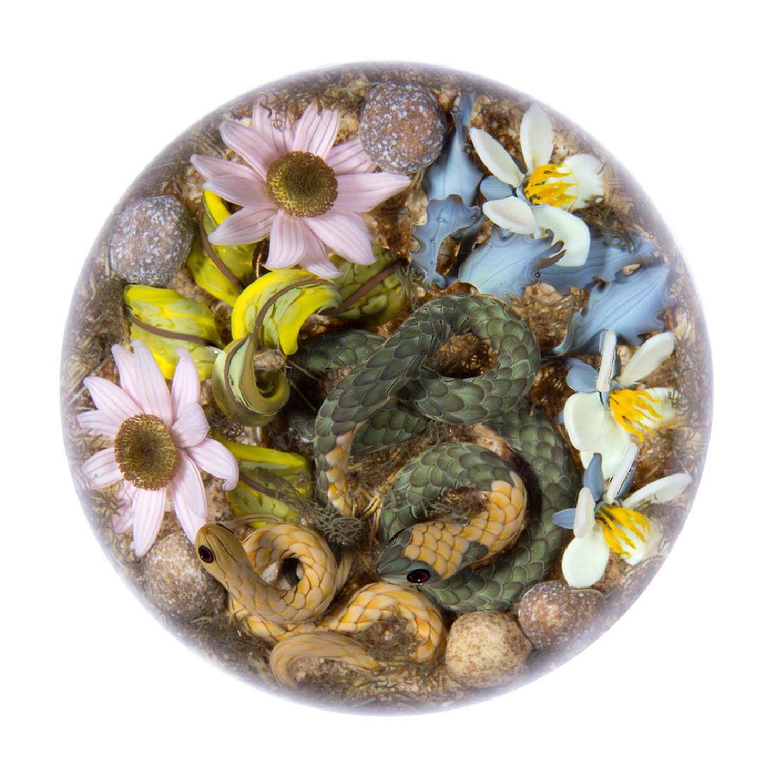GORDON SMITH STUDIO ART GLASS LAMPWORK PAPERWEIGHT: GORDON SMITH STUDIO ART GLASS LAMPWORK PAPERWEIGHT, depicting a green and tan snake and a smaller tan snake, each finely detailed including scales and two-tone eyes, pink daisy or similar blossoms on