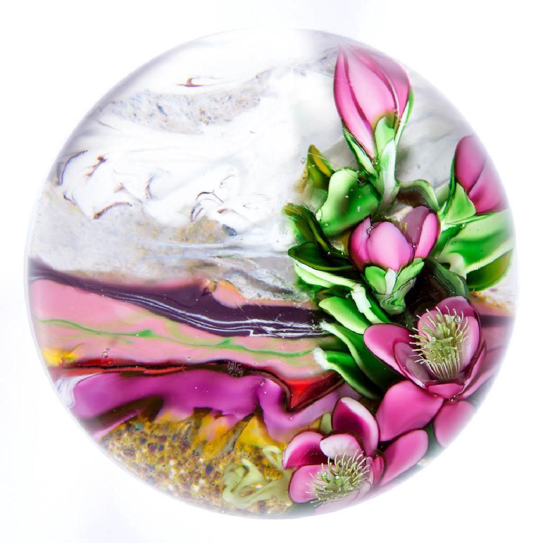 ERIC HANSEN STUDIO ART GLASS LAMPWORK PAPERWEIGHT: ERIC HANSEN STUDIO ART GLASS LAMPWORK PAPERWEIGHT, depicting large vibrant pink blossoms on green foliage, with a section of marbled white and gray ground invoking a wintery landscape, and a section o
