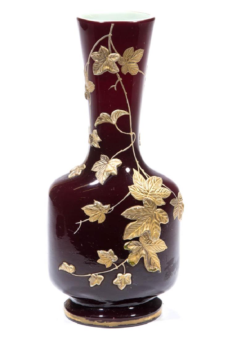 THOMAS WEBB ART GLASS VASE: THOMAS WEBB ART GLASS VASE, deep burgundy exterior with an opaque white interior, tapered neck with a squared body, circular foot, gilt gesso foliate decoration, polished pontil mark holding a faint "