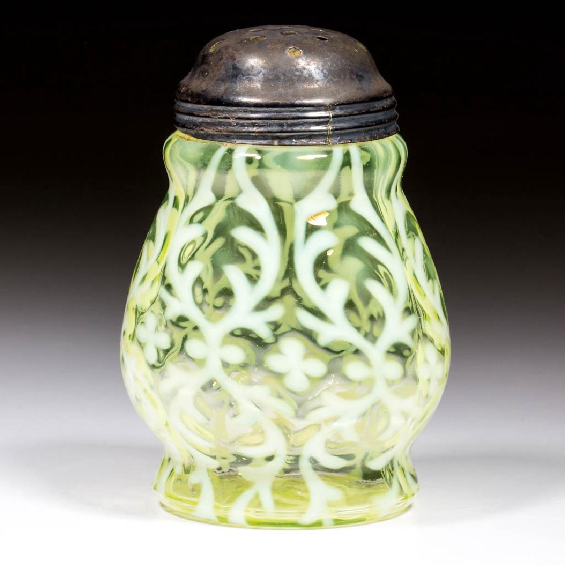 OPALINE BROCADE / SPANISH LACE SUGAR SHAKER: OPALINE BROCADE / SPANISH LACE SUGAR SHAKER, Vaseline (black lighted) opalescent, period lid. Northwood Glass Co. Circa 1899. 4 3/4" H.Very good condition overall with a small check to the rim.Literat