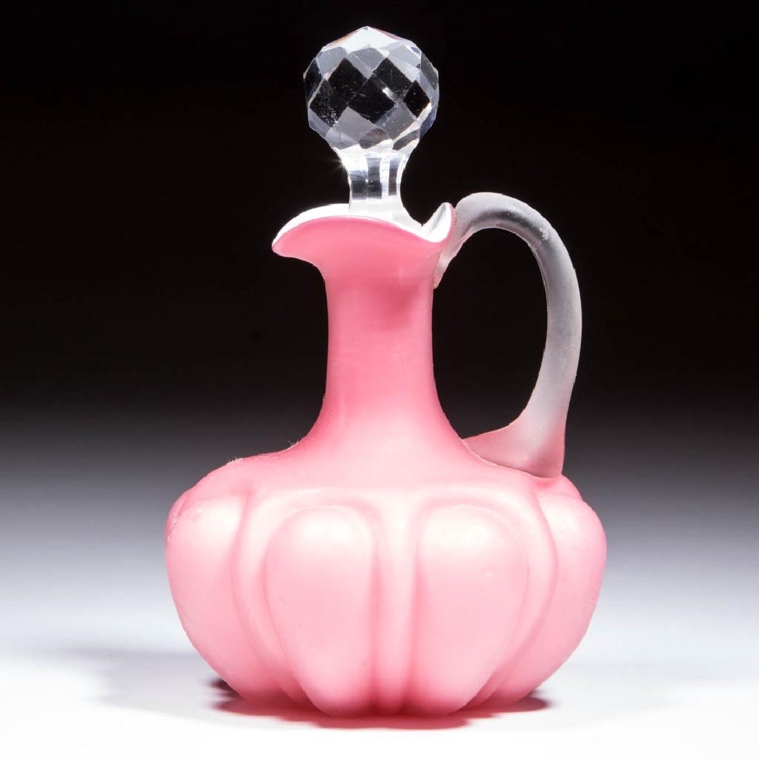 BULGING LOOPS CRUET: BULGING LOOPS CRUET, opal-cased pink, plush finish, cut stopper slightly ill-fitting, applied colorless handle with plush finish, polished pontil mark. Consolidated Lamp & Glass Co. Circa 1894. 5 5/8"