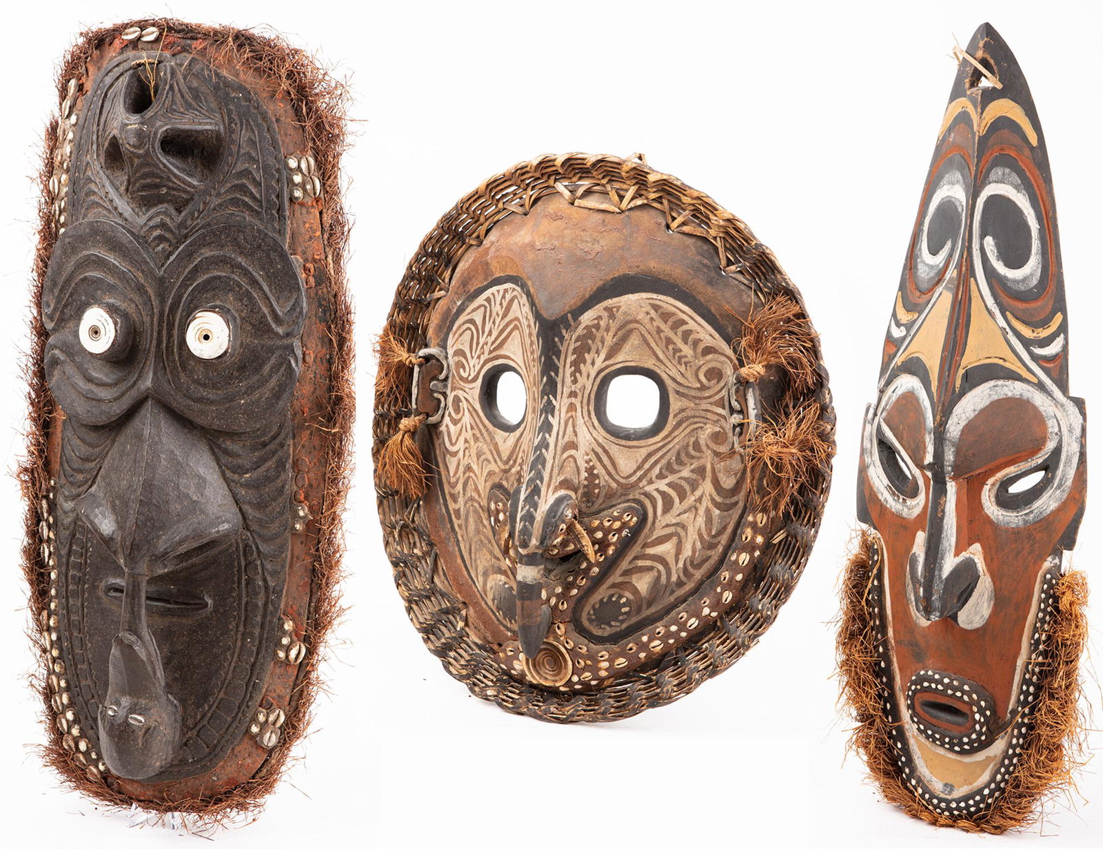 Three (3) Large Sepik River, Papua, New Guinea Hand: Three (3) Large Sepik River, Papua, New Guinea Hand Carved Masks: Wood, Woven Cane, Raffia, Organic Pigments and Cowry Shells. Three large wood carved Sepik River mask from Papua, New Guinea. Each qui
