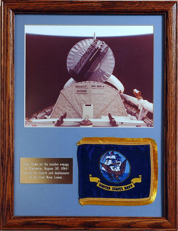 STS-41D, 1984, FLOWN US NAVY Flag: STS-41D, 1984, FLOWN "US NAVY" Flag (6x5", professionally matted and framed to 13.5x17"). The flag is framed along with a photo of the Hughes "Leasat F1" satellite at t