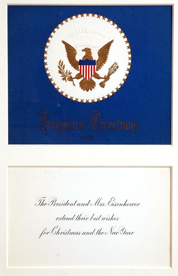 [Eisenhower, Dwight D. and Mamie]: [Eisenhower, Dwight D. and Mamie]. Official 1955 Christmas card engraved "Seasons Greetings 1955" in gold against a blue background, below a patriotic gold eagle bearing a red, white, and blue