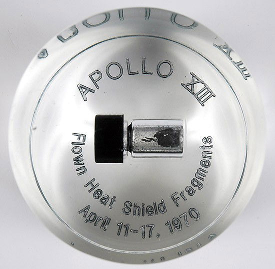Apollo 13, FLOWN Heatshield Fragments: Apollo 13, FLOWN Heatshield Fragments. Mounted in a clear lucite cylinder (3x3") that is engraved on the bottom: "Apollo XIII / Flown Heat Shield Fragments / April 11-17, 1970". Co