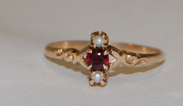 Ruby Spinel Ring: Ruby Spinel Ring accented by 2 small white pearls. Stamping work on band. 10K gold. 1.2 grams total weight.