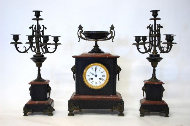 H & F Paris French Marble Garniture Set: Brass movement marked "H & F Paris" Mid 19th Century. Enamel Dialed Mantel Clock comprised of Red Marble and engraved black slate surmounted with a classical handled urn. Lion's head mounts on sides.